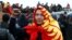 A demonstrator wearing the national flag in Bishkek gestures during an October 6, 2020 protest against the results of Kyrgyzstan's parliamentary election.
