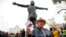 Russia -- An opposition activist holds the Russian Constitution book in front of the monument to Soviet-era opposition legendary bard Vladimir Vysotsky during a protest in the center of Moscow, Russia, Saturday, Aug. 17, 2019