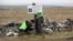 Dutch investigators place a sign near Malaysia Airlines Flight MH17 plane crash site