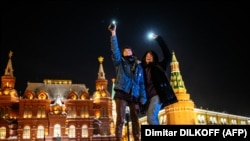 Young people near Moscow's Red Square turn on the flashlights of their cell phones to support jailed opposition politician Aleksei Navalny  on February 14, 2021.