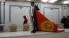 A protester carries the Kyrgyz flag inside a seized government building in Bishkek on October 6, 2020.