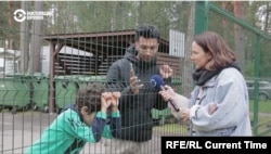 Using a digital translator on his smartphone, Iranian migrant Amir Chani talks with Current Time Riga correspondent Marija Andrejeva at Latvia's Mucenieki migrant detention center.
