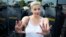 With police to her back, Belarusian opposition leader Maryya Kalesnikava mimes pushing back protesters during a rally in Minsk on August 30, 2020.
