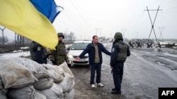 Украинские военные проверяют документы у водителя на КПП в Курахово. Январь 2015 года