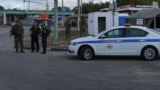 Russian law enforcement officers stand guard at a checkpoint in Belgorod