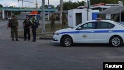 Russian law enforcement officers stand guard at a checkpoint in Belgorod