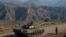 Servicemen from Russian peacekeeping troops stand next to a tank near the Armenian border following the signature of a November 9, 2020 deal to end the military conflict between Azerbaijan and ethnic Armenian forces in the breakaway region of Nagorno-Karabakh. 
