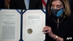 U.S. House of Representatives Speaker Nancy Pelosi (Democrat-California) displays the signed Article of Impeachment against President Donald Trump on January 13, 2021. 